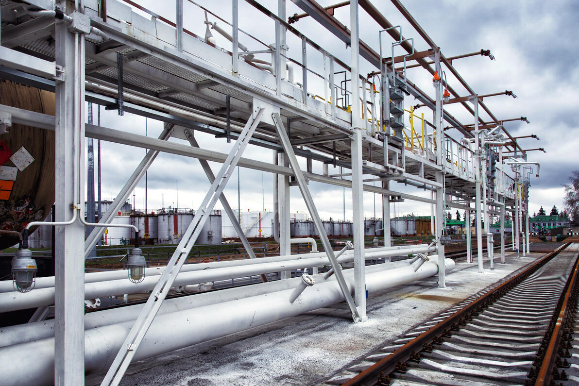 Steel unloading structure for rail or truck applications with access walkways and pipe systems.